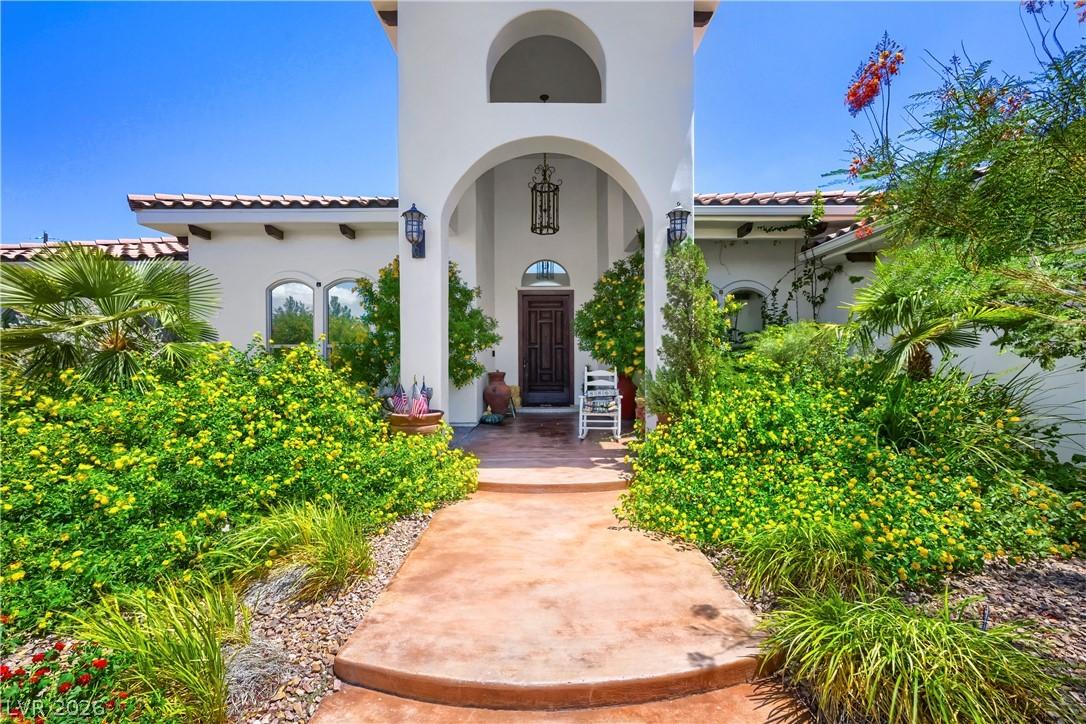 Image 3: An inviting entry features lush, vibrant landscapi