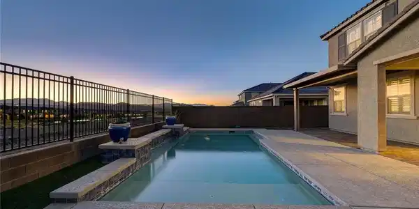 Image 2: Concrete decking surrounds a sparkling in-ground p