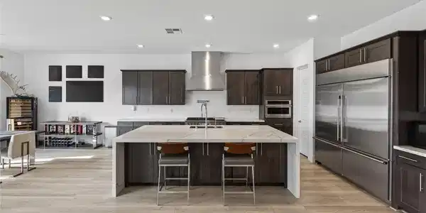 Image 3: A pristine kitchen features modern cabinetry, a ge