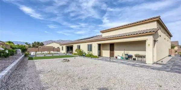 Image 4: A spacious backyard with desert landscaping and a