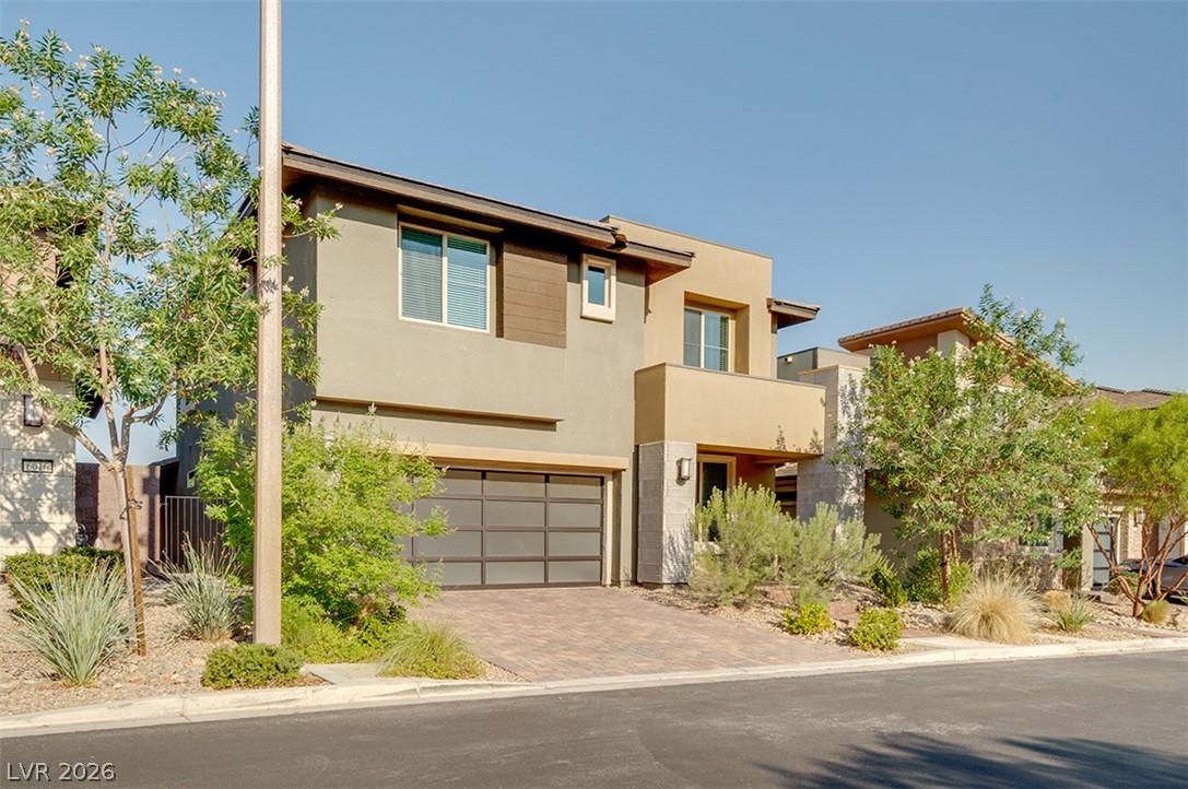 Image 2: Modern desert architecture with a paver driveway,