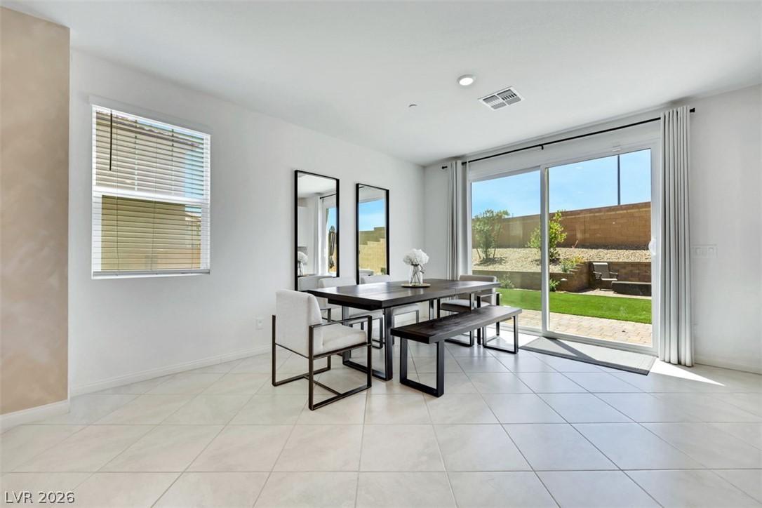 Image 2: This spacious dining area features sleek tile floo