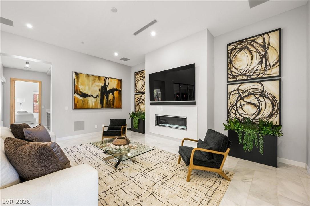 Image 2: Living room featuring a glass covered fireplace an