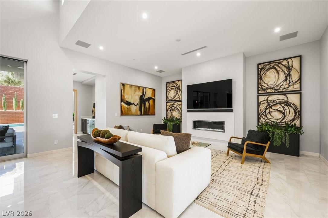 Image 3: Living room featuring a glass covered fireplace, r