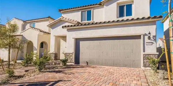 Image 2: A grand exterior showcases stucco, stone accents,
