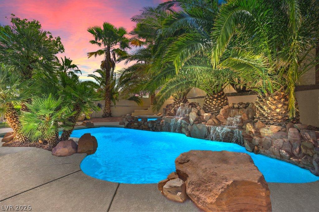Image 2: A vibrant oasis with a rock waterfall pool, framed