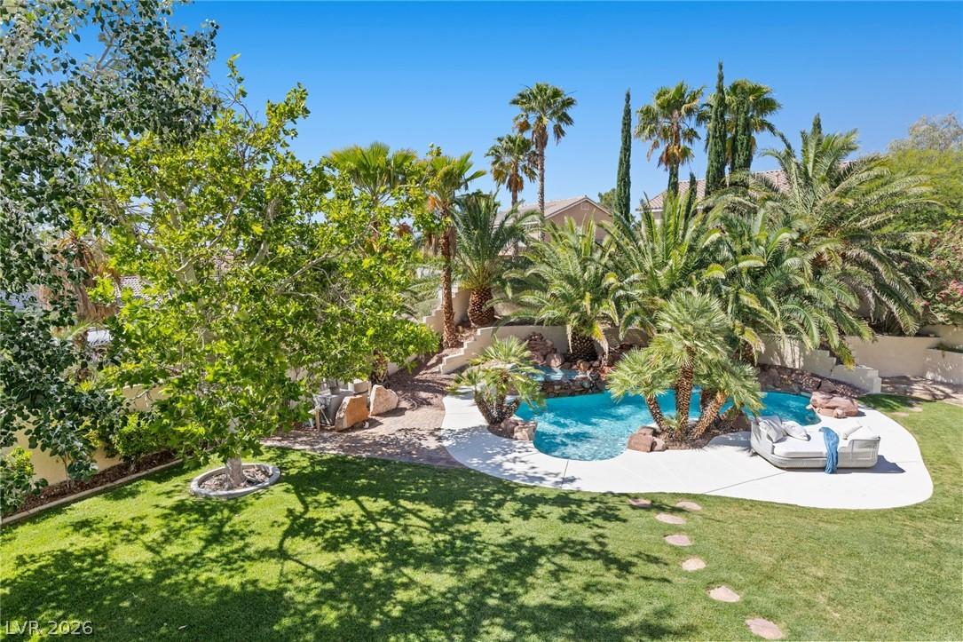 Image 4: Lush landscaping surrounds a sparkling pool with a
