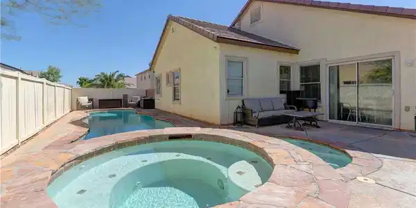 Image 2: A private backyard oasis features a shimmering poo