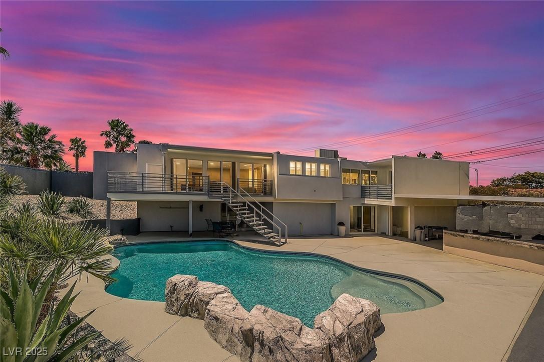 Image 1: View of pool featuring stairway and a patio