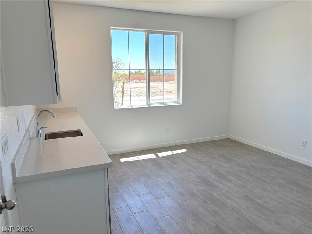 Image 4: Kitchen with wood tiled floors, white cabinets, an