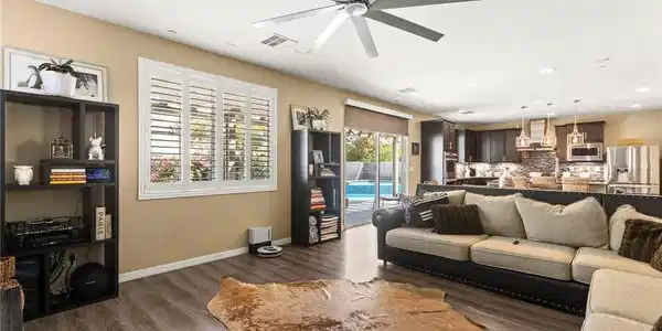 Image 2: A spacious living area with warm wood flooring ope