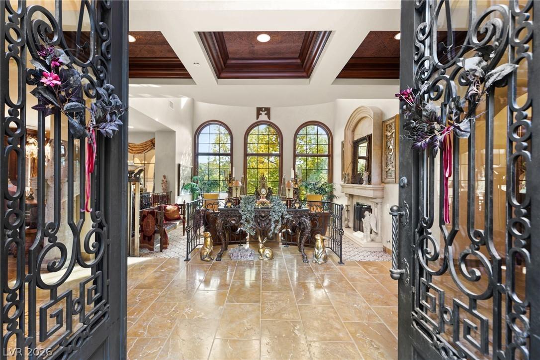 Image 2: Ornate wrought iron doors open to an inviting foye