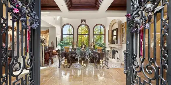 Image 2: Ornate wrought iron doors open to an inviting foye