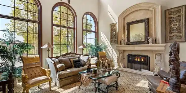 Image 3: Ornate fireplace and grand arched windows define t