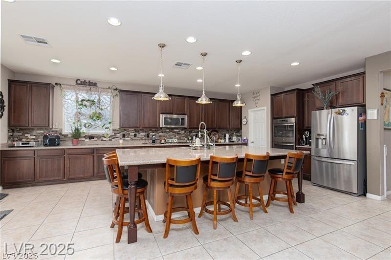 Image 4: This kitchen features a central island with bar se