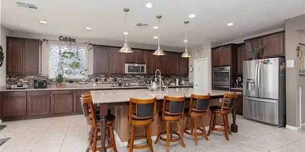 Image 4: This kitchen features a central island with bar se
