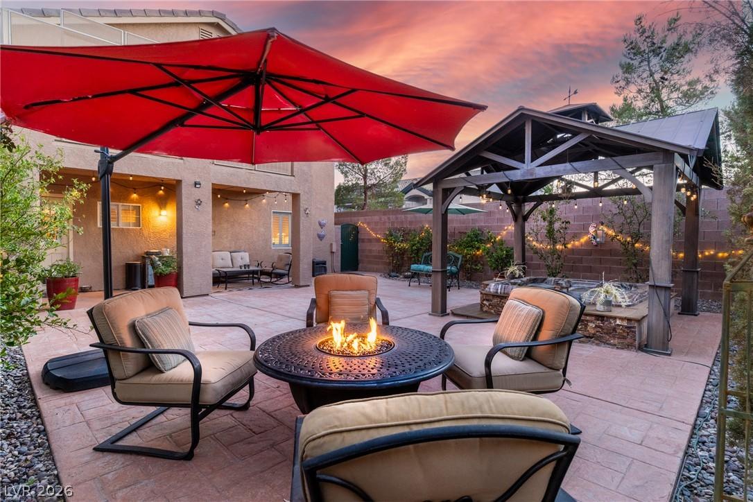 Image 3: An inviting backyard retreat features a fire pit,
