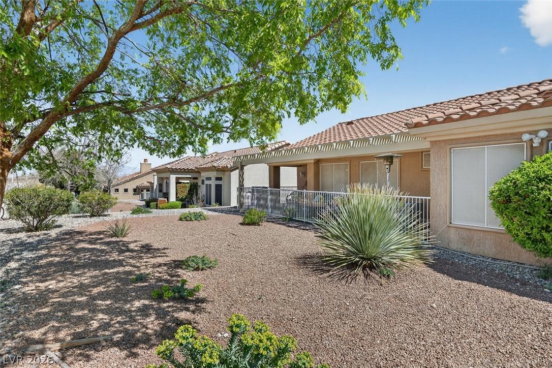 Image 3: Back of house with stucco siding and a tile roof
