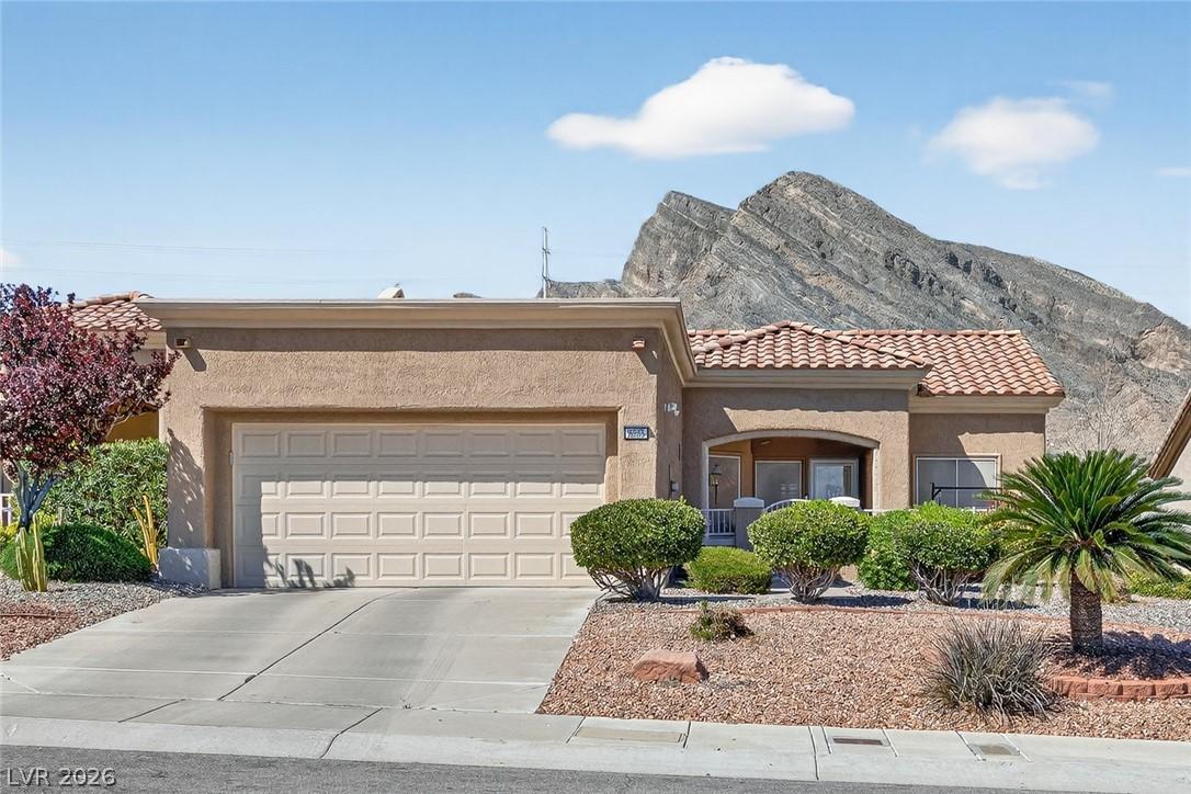 Image 4: View of front of house with a tile roof, stucco si