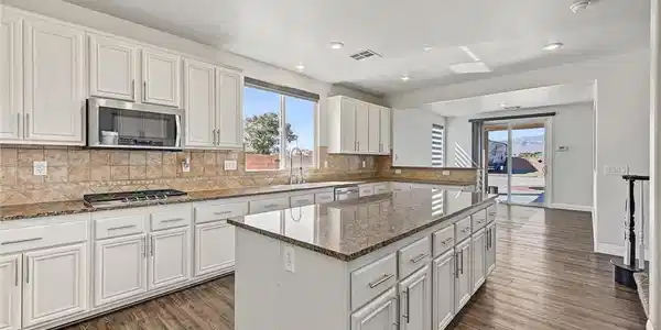 Image 3: Polished granite countertops and classic LVP floor