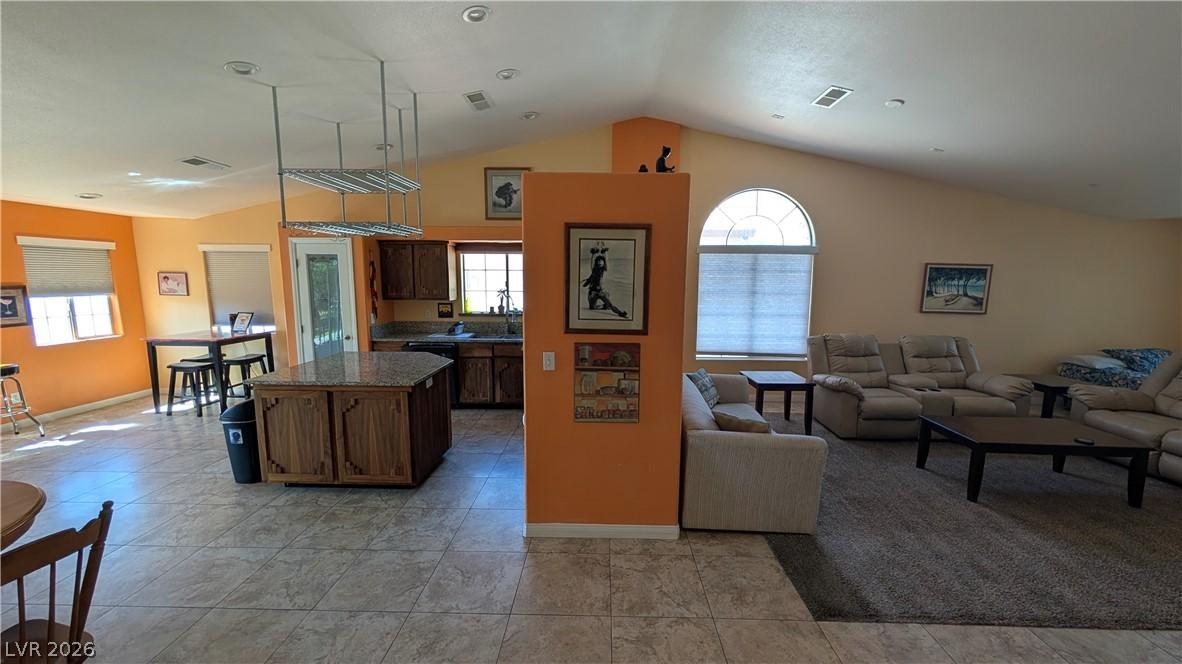 Image 4: An open concept living area features vaulted ceili