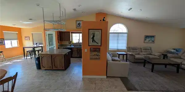 Image 4: An open concept living area features vaulted ceili