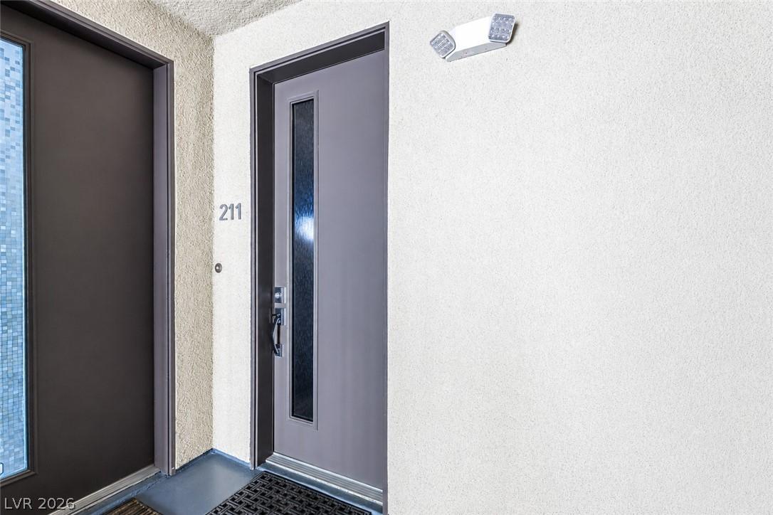 Image 2: Secure entry to unit 211, offering a modern door w