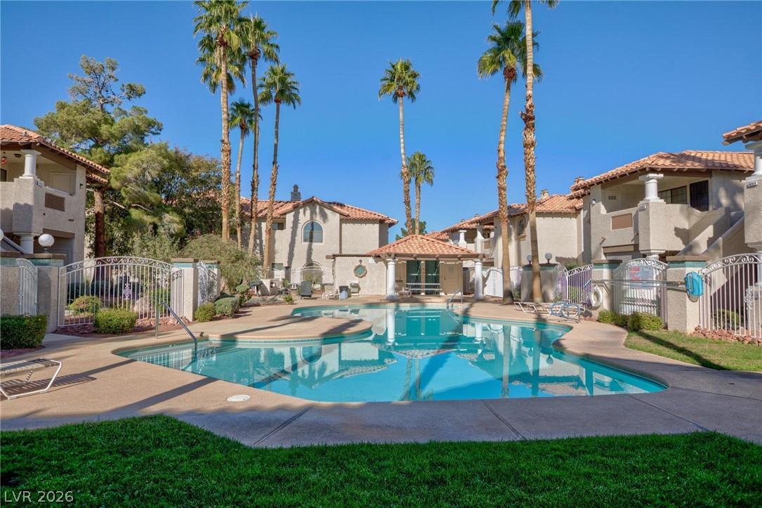 Image 2: A refreshing pool area surrounded by palm trees an