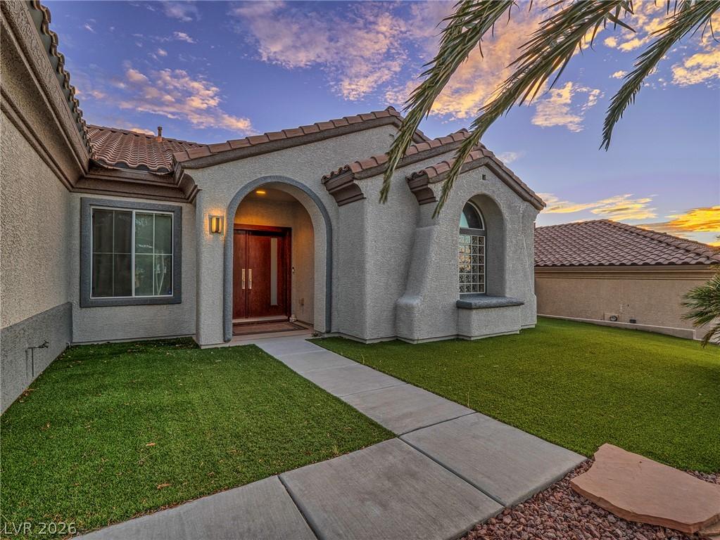 Image 2: Arched entry and tiled roofing enhance this home's