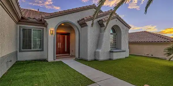 Image 2: Arched entry and tiled roofing enhance this home's