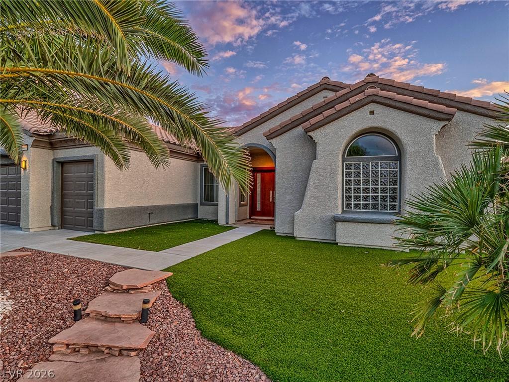 Image 3: An inviting entry to this stucco home, framed by l