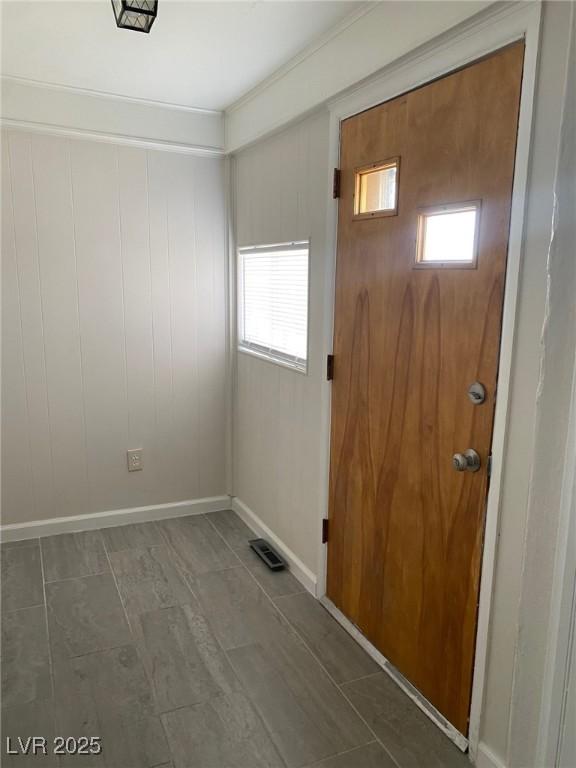 Image 3: Foyer entrance with wood walls, wood finished floo