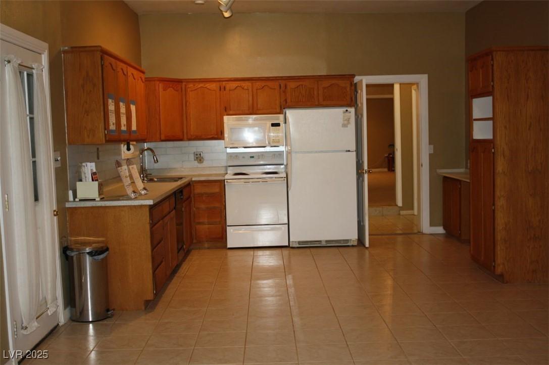 Image 2: Kitchen featuring white appliances, light countert