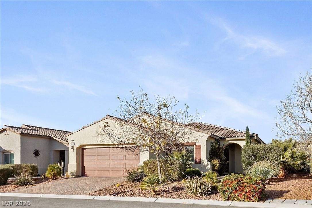 Image 1: Front of home with desert landscaping and a tiled