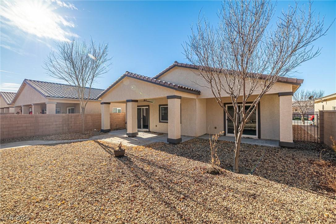 Image 2: Rear view of house featuring stucco siding, a pati