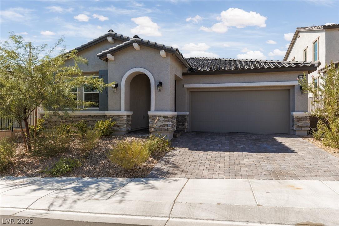 Image 1: A welcoming facade features a paver driveway, an a