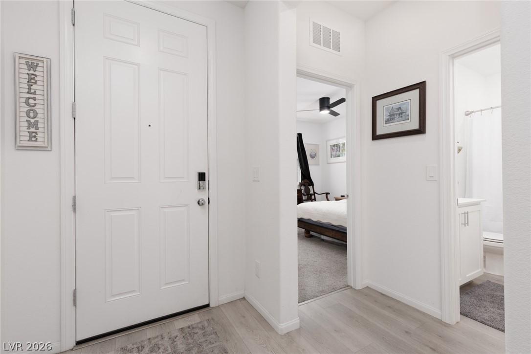 Image 2: Upon entry, discover light-hued flooring leading t