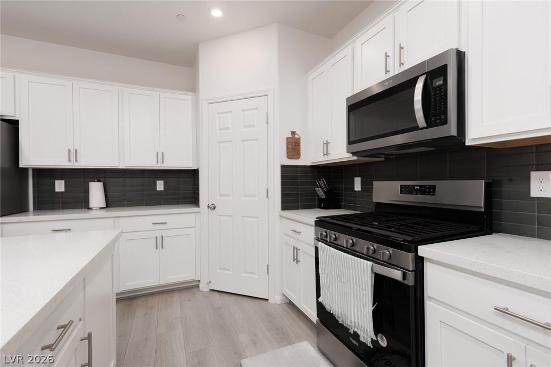 Image 3: Modern kitchen with sleek cabinetry, a gas range,