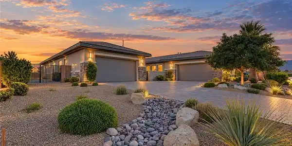 Image 2: Desert landscaping and a paved driveway lead to th