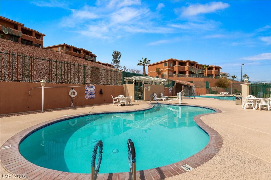Image 4: An inviting pool area awaits, nestled against terr