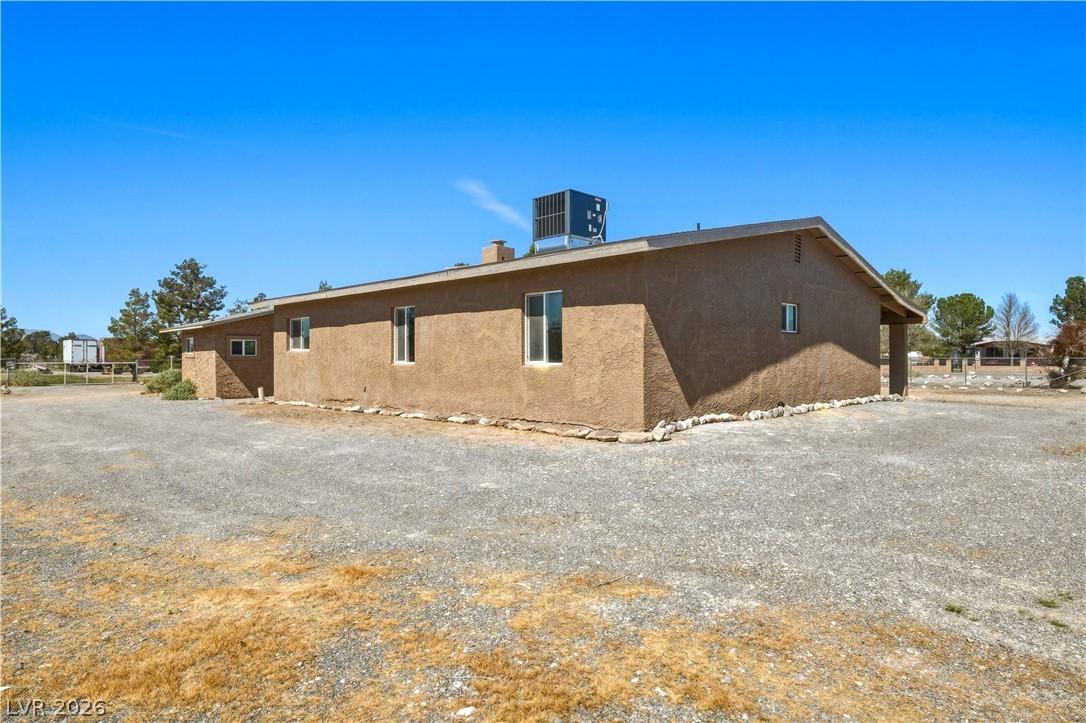 Image 4: View of property exterior with stucco siding and a
