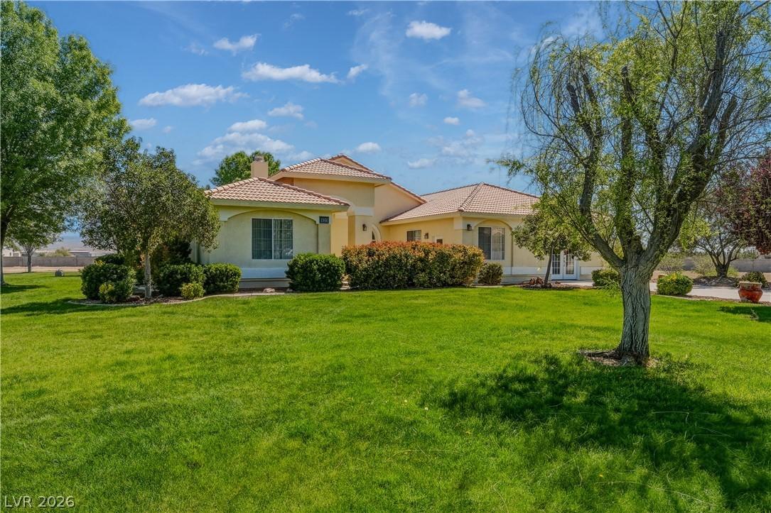 Image 1: View of front of home with a front yard, a tiled r