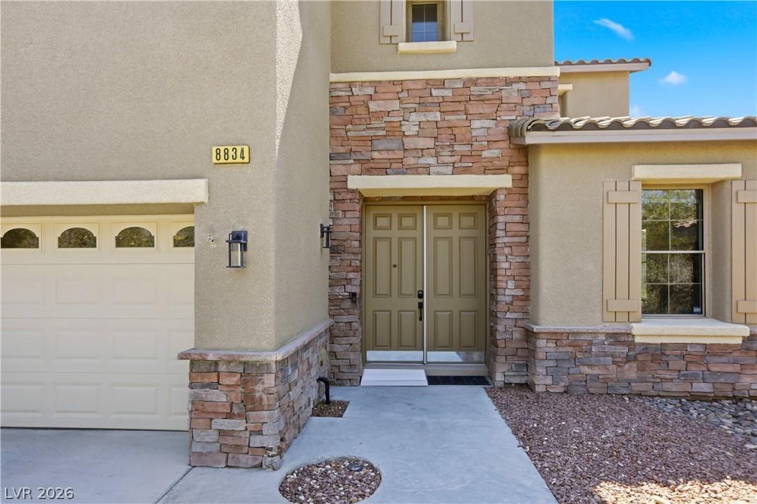 Image 4: A welcoming stone and stucco facade with a double-