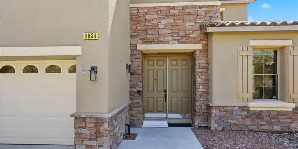 Image 4: A welcoming stone and stucco facade with a double-