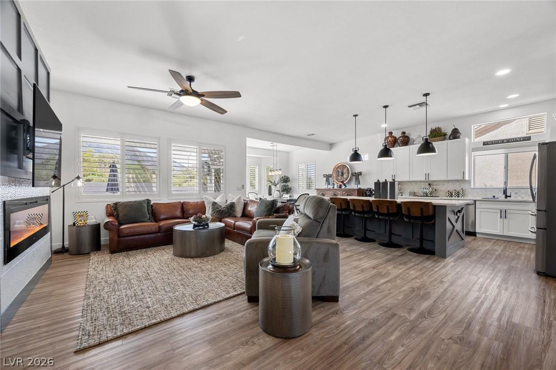 Image 2: An open-concept living space features wood floorin
