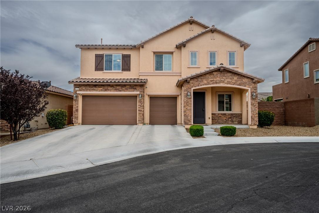 Image 4: Two-story home with a stone-accented facade and tw