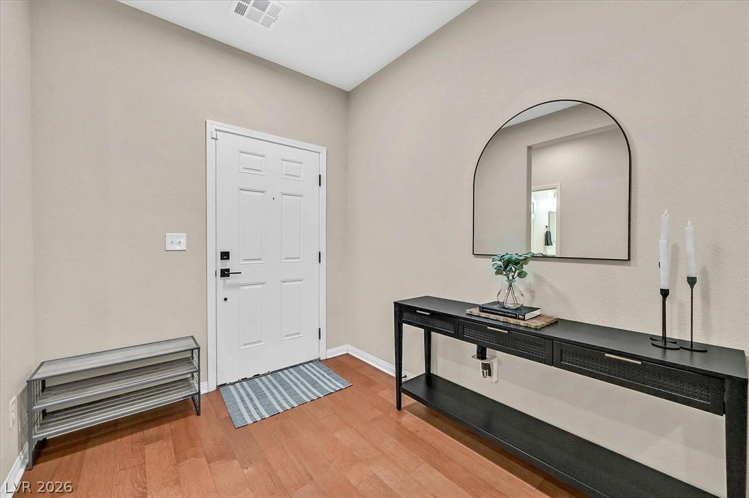 Image 3: A welcoming entryway with gleaming wood floors and