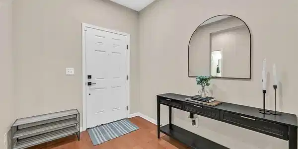 Image 3: A welcoming entryway with gleaming wood floors and