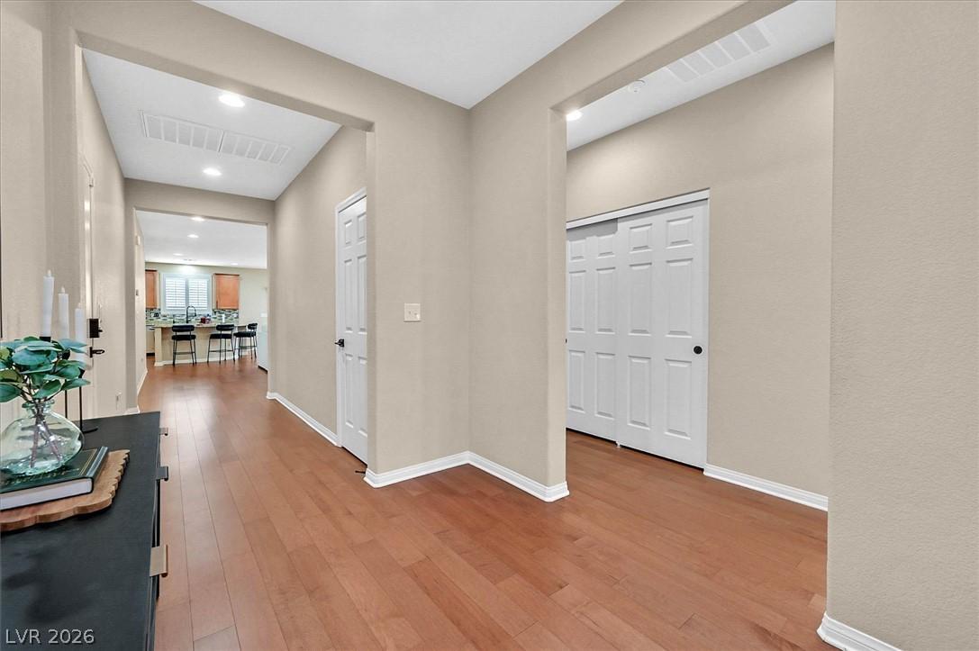 Image 4: A warm wooden floor leads into a bright, open livi