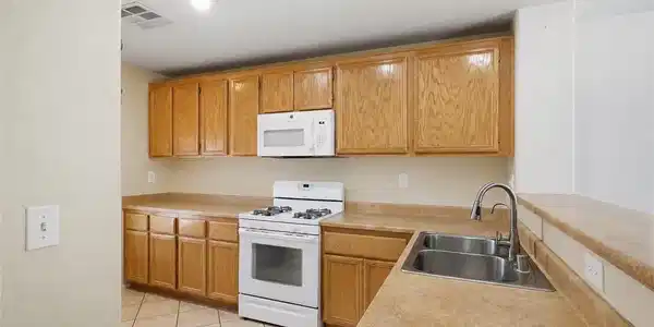 Image 4: A functional kitchen features warm wood cabinetry